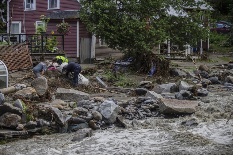 Image: Residents collect debris following flooding 