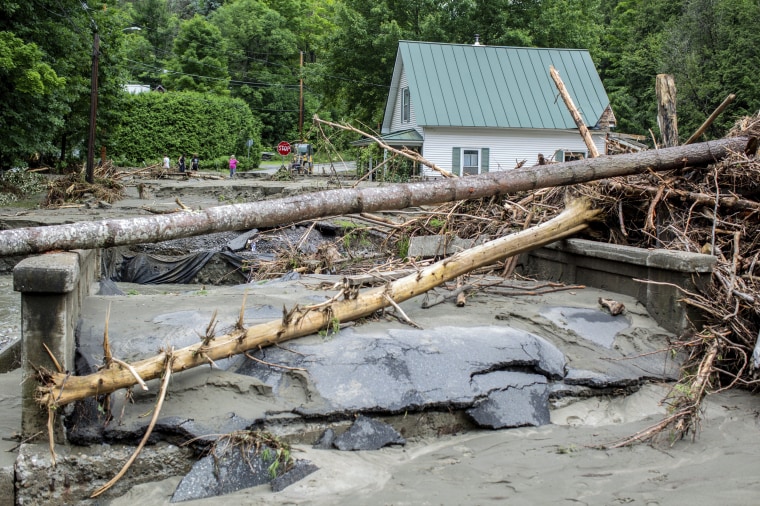 Image: Debris is strewn about a damaged bridge over the Winooski River 