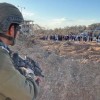 An Israeli soldier watches as Palestinian families flee south on the edge of Gaza City on Nov. 15, 2023.