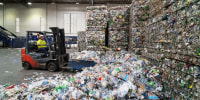 An employee operates a forklift  at a plastics recycling plant in California.