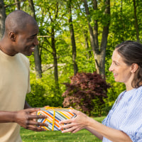 Woman giving a gift to her husband outdoors