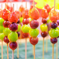 Beautifully arranged sugar-coated grape and strawberry tanghulu.