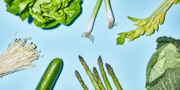 Different sorts of green vegetable on blue background