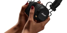 Hands holding Marshall Major V headphones