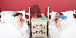 Young couple smiling at each other in two single beds.