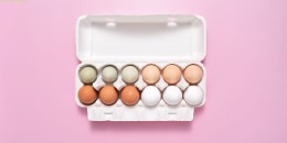 carton of eggs on pink background.