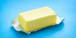 Single butter stick on blue background.