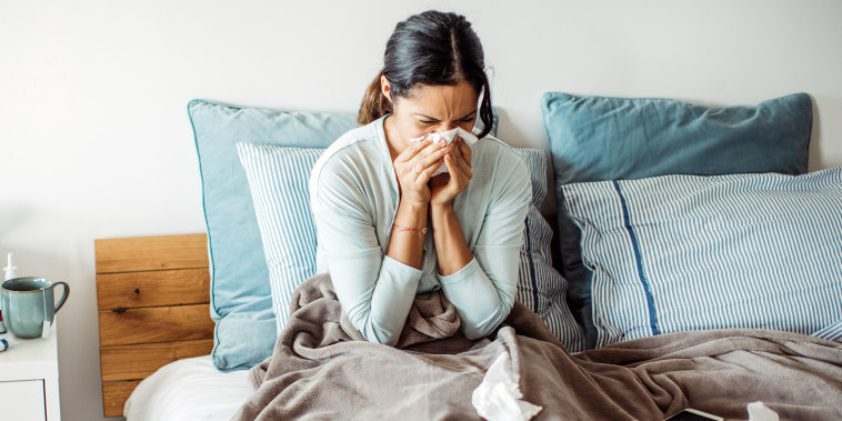 Woman with flu in bed, she use home medicine to handle sickness