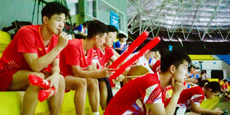 Players sit in the stands as they watch their teammates