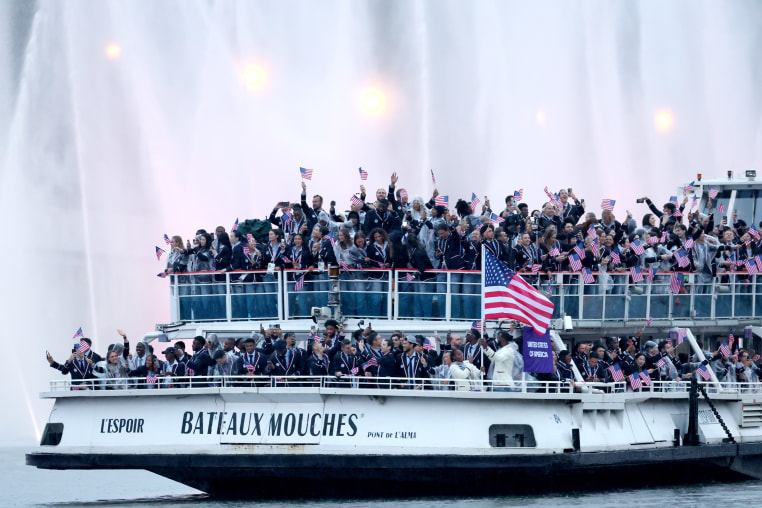 Members of Team USA pass water jets after going through the water curtain under the Austerlitz Bridge in Paris.