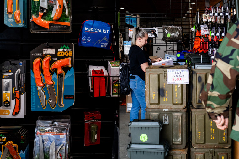 (Left) Outdoor safety and camping gear for sale. (Right) An attendee looks at safety gear and different kinds of equipment for sale at a vendor's booth during an Great Lakes Emergency Preparedness Expo in Imlay City, Mich., on Sept. 14, 2024. 