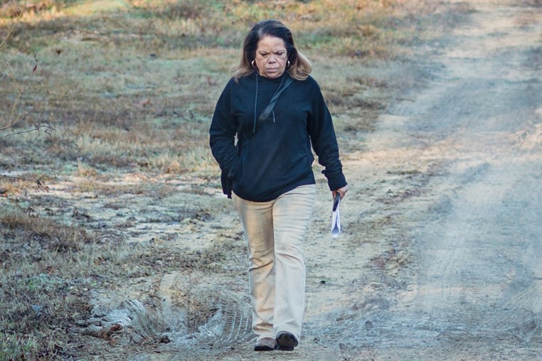 Sharon Grisham-Stewart walks outside on a dirt road