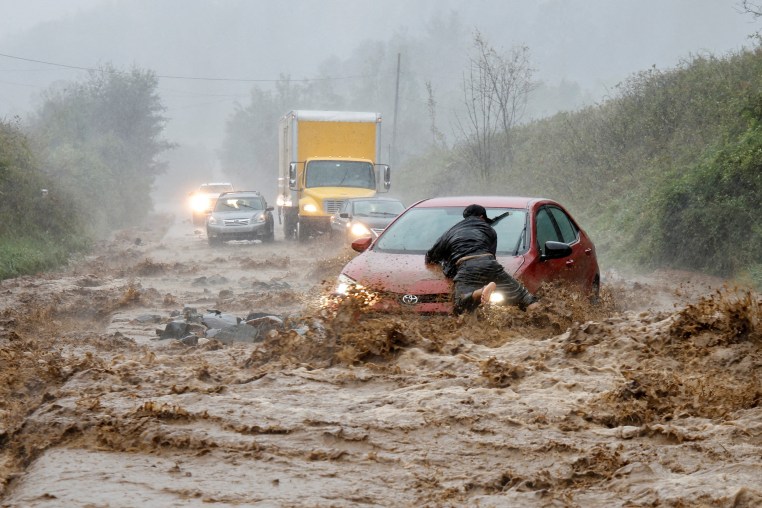 A resident helps free a stranded car as Tropical Storm Helene strikes Boone, North Carolina