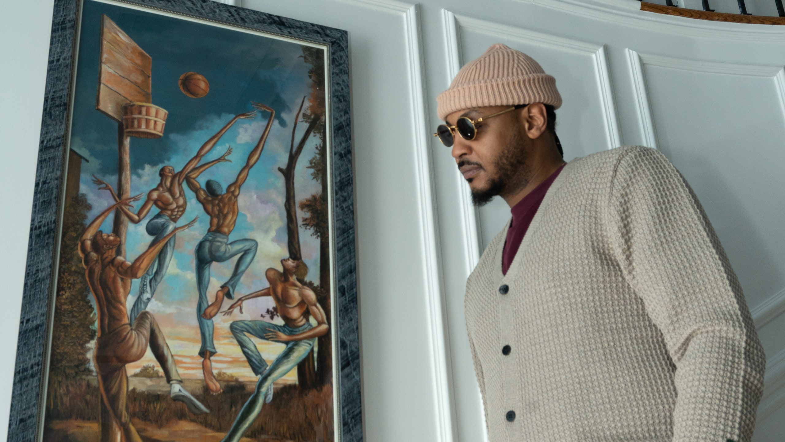 Carmelo Anthony in stairway next to an Ernie Barnes artwork on wall