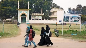 Photo: PTI : Past and Present: Muslim women walk past the land allocated for the construction of Muhammad Bin Abdullah Masjid in Ayodhya