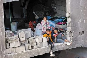 Photo: Getty Images : Children look on as civil defence teams conduct rescue operations following an Israeli attack in Gaza
