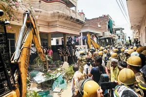 Photo: PTI : State Power: Security forces and local people in Prayagraj witness the demolition of the house of a person accused of inciting violent protests in 2022