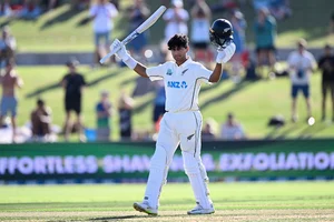 Photo: Andrew Cornaga/Photosport via AP                  : Rachin Ravindra celebrates his century during the first day of the first cricket Test match between New Zealand and South Africa at Bay Oval, Mount Maunganui.