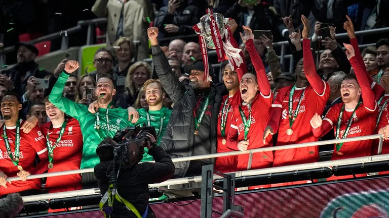 Liverpool's manager Jurgen Klopp and players celebrate with English League Cup trophy at Wembley Stadium in London on February 25, 2024. They beat Chelsea 1-0 in the final. - AP Photo