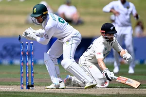 (Andrew Cornaga/Photosport via AP) : South Africa wicketkeeper Clyde Fortuin, left, attempts to run out New Zealand's Kane Williamson on the fourth day of 2nd Test.