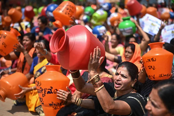 Activists of the BJP hold empty water pots as they shout slogans during a protest against the state government over ongoing severe water crisis, in Bengaluru on March 12, 2024. - Getty Images