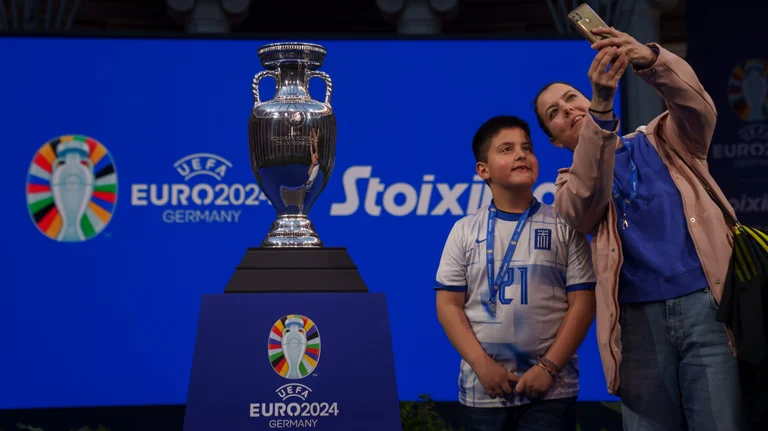 A mother with her boy takes a selfie next to the 2024 UEFA European Championship trophy. Germany host the Euro 2024. - AP/Petros Giannakouris