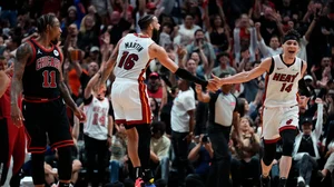 Caleb Martin #16 celebrates scoring a three-pointer with Tyler Herro #14 of the Miami Heat against the Chicago Bulls in the third quarter during the Play-In Tournament at Kaseya Center on April 19, 2024