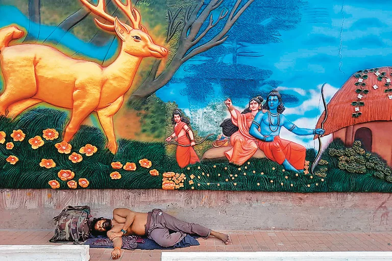 Blessed Slumber: A man taking rest below a painting of Ram and Sita spotting a golden deer - Photo: Satish Padmanabhan