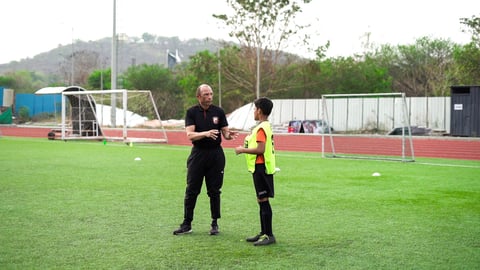 Terry Phelan discussing something with a kid in SUFC.