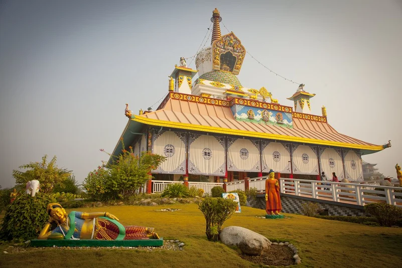 A grand building in Lumbini featuring a colossal Buddha statue.