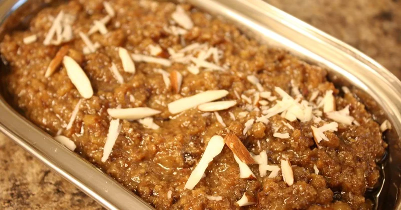 A bowl of Date and Walnut Halwa topped with almonds.