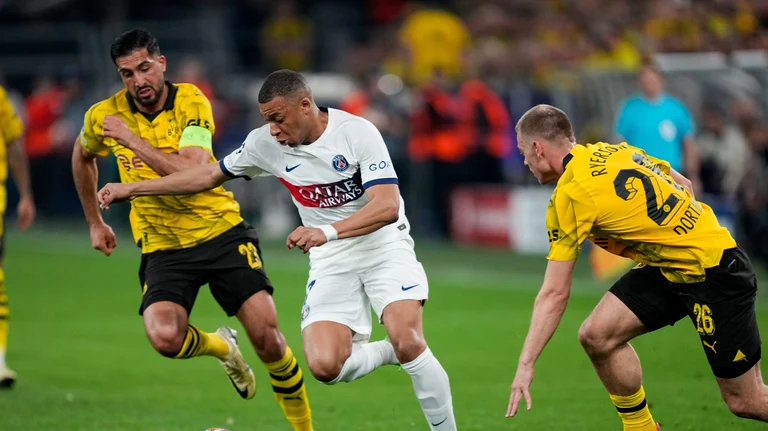 PSG's Kylian Mbappe, center, dribbles the ball past Dortmund's Emre Can, left, during the Champions League semifinal first leg soccer match between Borussia Dortmund and Paris Saint-Germain at the Signal-Iduna Park in Dortmund. - AP Photo/Martin Meissner