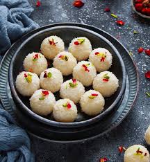 Indian coconut ladoo in a bowl on a dark table.