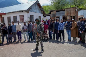 AP/Dar Yasin : An Indian paramilitary soldier guards as Kashmiri villagers stand in a queue to cast their votes during the fourth phase of India's general election in Gund, northeast of Srinagar, Indian controlled Kashmir, Monday, May 13, 2024.