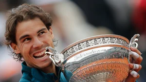 AP : Spain's Rafael Nadal bites the trophy after winning against compatriot David Ferrer in three sets 6-3, 6-2, 6-3, in the final of the French Open tennis tournament, at Roland Garros stadium in Paris, Sunday June 9, 2013.