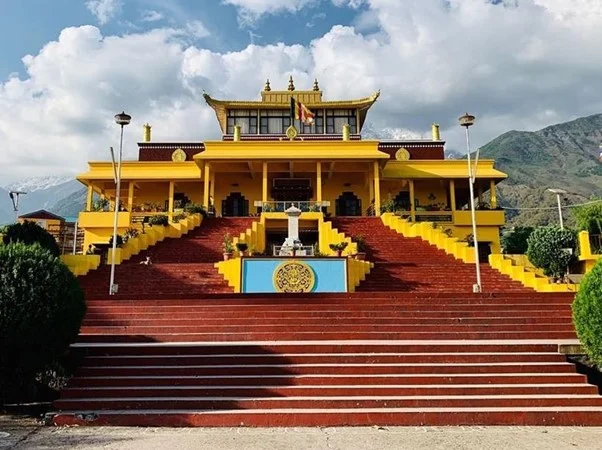 A yellow temple with steps leading up to it. Namgyal Monastery, a serene and vibrant place of worship.