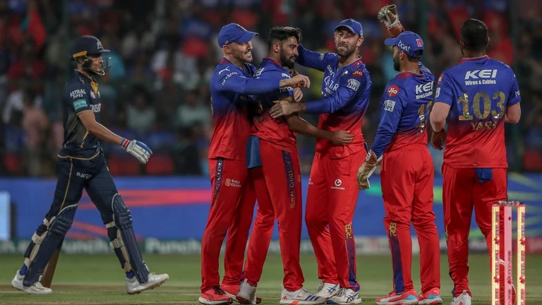 Royal Challengers Bengaluru's Mohammed Siraj, center without cap, celebrates with teammates after the dismissal of Gujarat Titans' captain Shubman Gill, left, during the Indian Premier League cricket match between Royal Challengers Bengaluru and Gujarat Titans in Bengaluru, India, Saturday, May 4, 2024.  - (AP Photo)