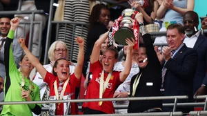 Marc Skinner lifts the Women's FA Cup trophy with Millie Turner on Sunday.