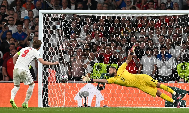 FILE - England's Harry Kane left, shoots to score past Italy's goalkeeper Gianluigi Donnarumma during penalty shootout of the Euro 2020 soccer championship final match between England and Italy at Wembley Stadium in London, Sunday, July 11, 2021. The penalty shootout is a tense battle of wills over 12 yards (11 meters) that has increasingly become a huge part of soccer and an unavoidable feature of the knockout stage in the biggest competitions.  - (Paul Ellis/Pool via AP, File)