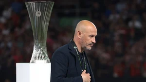 Vincenzo Italiano walks past the Europa Conference League trophy with a silver medal for a second straight year.