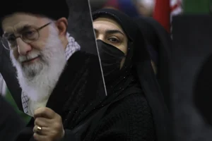 AP : An Iranian woman holds a poster of Supreme Leader Ayatollah Ali Khamenei |