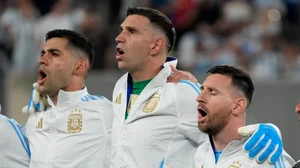 AP Photo/Pamela Smith : Argentina's Lionel Messi, right, and Cristian Romero flank goalkeeper Emiliano Martinez while singing the national anthem before the Copa America Group A football match against Chile in East Rutherford.