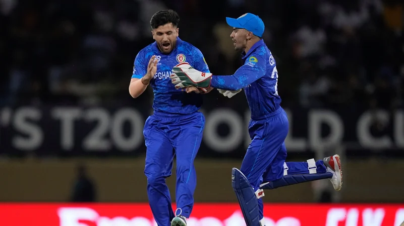 Afghanistans Fazalhaq Farooqi, left, celebrates with wicket keeper Rahmanullah Gurbaz taking the wicket of New Zealands Finn Allen. AP