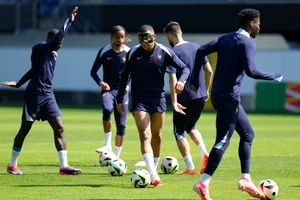 (AP Photo/Hassan Ammar) : France's Kylian Mbappe, center, warms up with his teammates during a training session in Paderborn, Germany, Monday, June 24, 2024. France will play against Poland during their Group D soccer match at the Euro 2024 soccer tournament on June 25. 