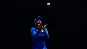 | Photo: AP/Ricardo Mazalan : Rashid Khan prepares to take o dismiss India's captain Rohit Sharma 