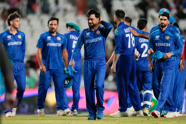 Afghanistan's captain Rashid Khan, centre, walks from the field with his players following their nine wicket loss to South Africa in their men's T20 World Cup semifinal cricket match at the Brian Lara Cricket Academy in Tarouba, Trinidad and Tabago, Wednesday, June 26, 2024.  - (AP Photo/Ricardo Mazalan)