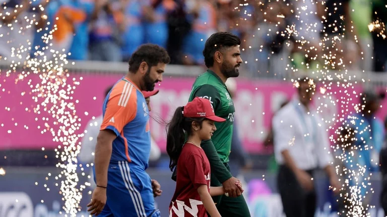 Pakistan's captain Babar Azam, right, and India's captain Rohit Sharma walk into the field before the start of the ICC Men's T20 World Cup cricket match between India and Pakistan at the Nassau County International Cricket Stadium in Westbury, New York, Sunday, June 9, 2024 - AP/Adam Hunger