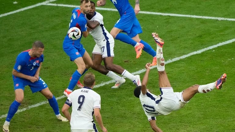 England's Jude Bellingham, right, scores his side's first goal with an overhead kick during a round of sixteen match between England and Slovakia at the Euro 2024 soccer tournament in Gelsenkirchen, Germany, Sunday, June 30, 2024. - AP/Ebrahim Noroozi