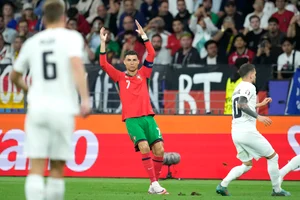 (AP Photo/Michael Probst) : Portugal's Cristiano Ronaldo, right, reacts during a round of sixteen match between Portugal and Slovenia at the Euro 2024 soccer tournament in Frankfurt, Germany, Monday, July 1, 2024. 