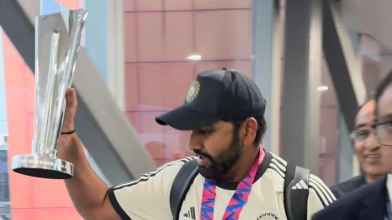 Rohit Sharma flaunts the World Cup Trophy as the Indian Cricket Team touch down in Delhi. - X/@DelhiAirport